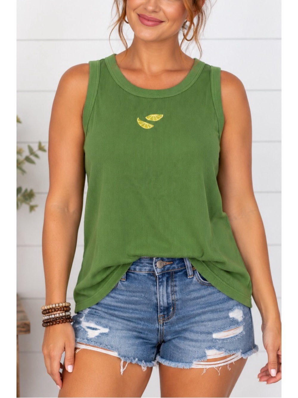 A New Day green tank top featuring machine embroidery of lime slices